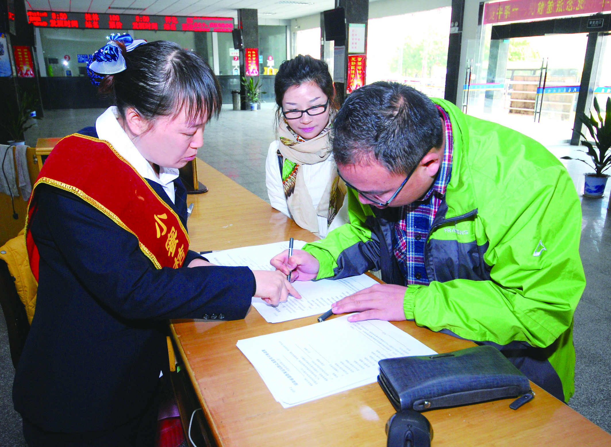 圖為洞口汽車總站站務(wù)人員在熱心為旅客服務(wù)。