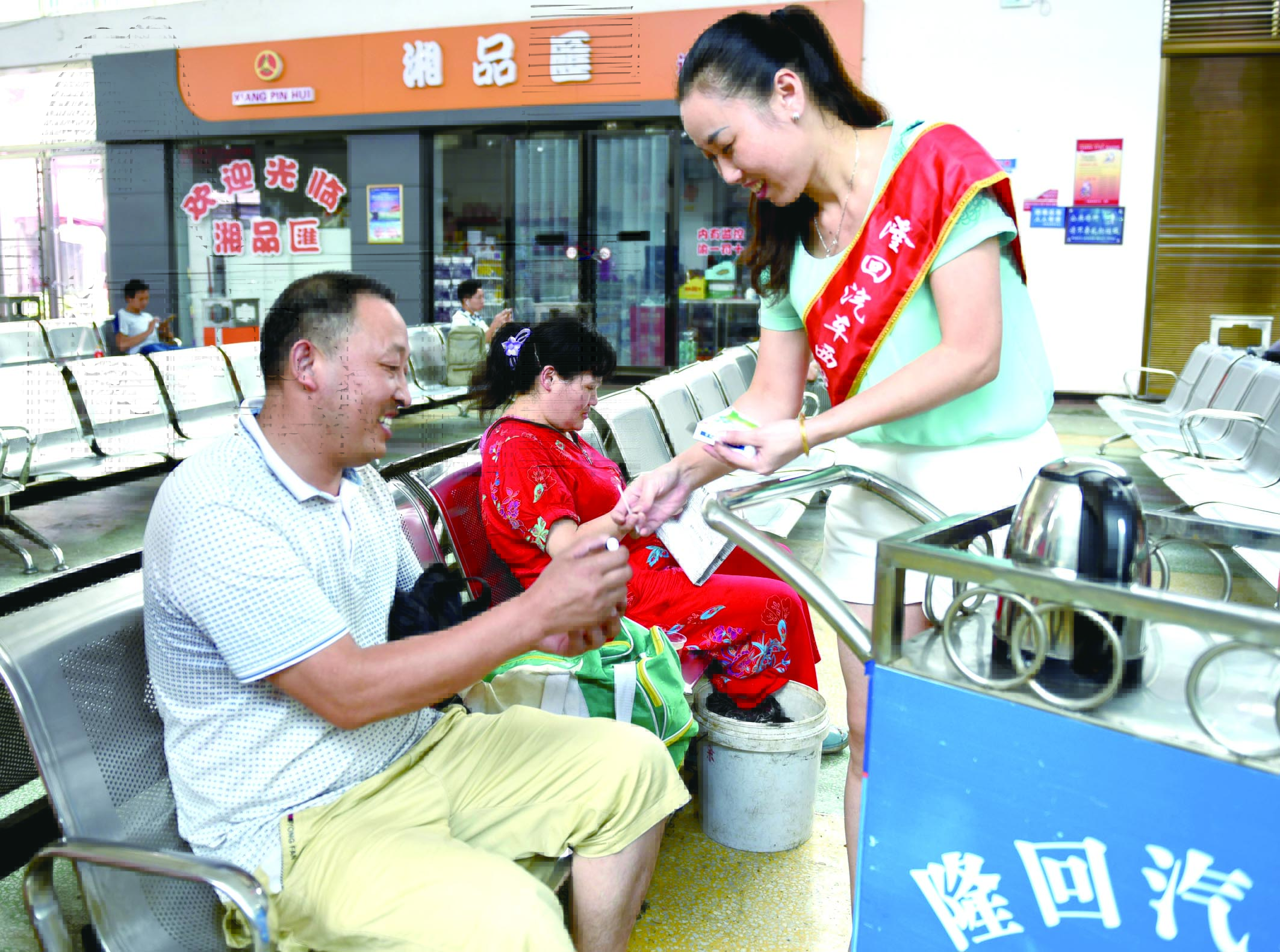 隆回分公司汽車(chē)西站工作人員正在為旅客免費(fèi)贈(zèng)送藿香正氣水。